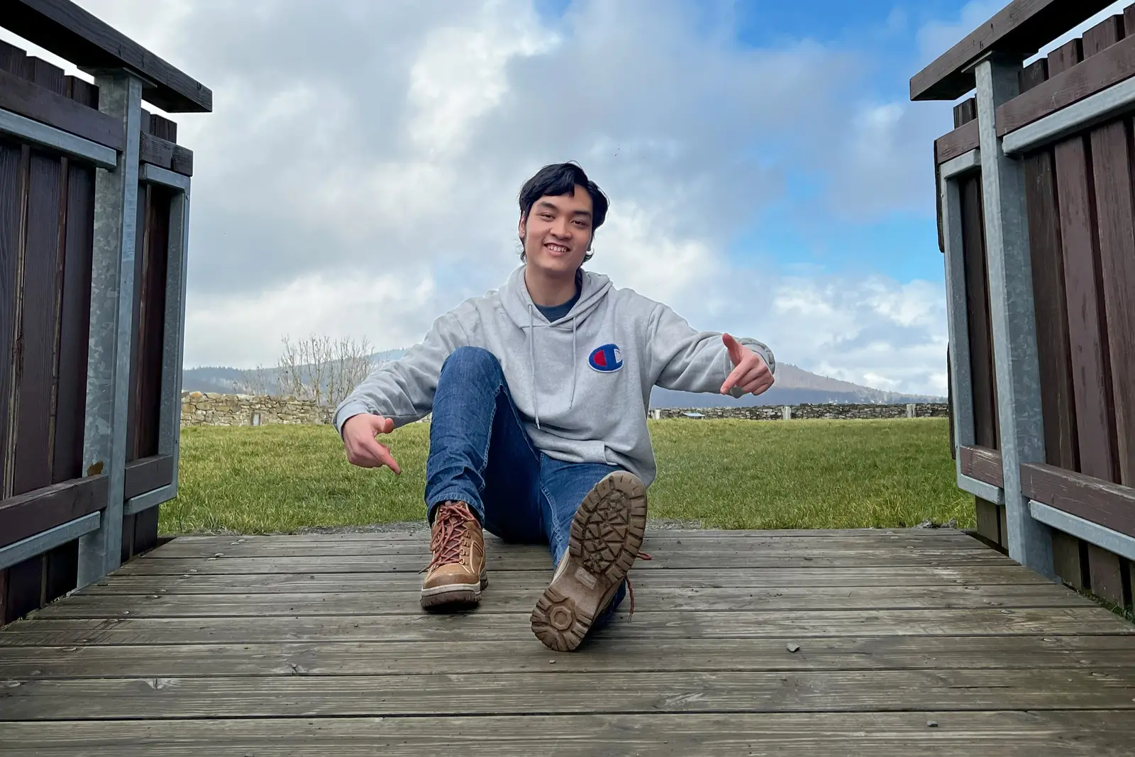 Nguyễn Ngọc Vĩnh sitting on a wooden bridge, smiling